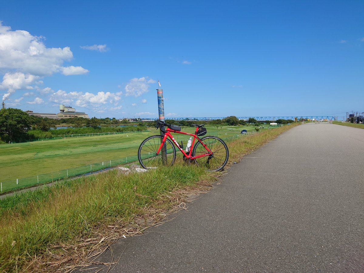 青空の河川敷サイクリングロードに停めた赤いTREK Émonda SL 6